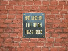 Plaque on a brick wall with inscription: Юрий Алексеевич Гагарин, 1934-03-09–1968-03-27