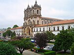 Church facade integrated into a complex of white buildings with red roofs