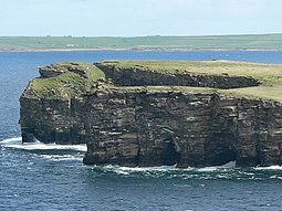 Grey Head, the northern tip of the Calf. Sea caves, and the beginning of an arch can be seen in the cliff.