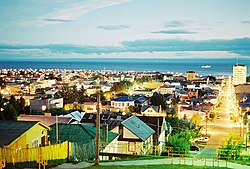 Pemandangan musim panas malam hari Punta Arenas. Dalam latar belakang Selat Magellan dan pantai utara Tierra del Fuego (Isla Grande de Tierra del Fuego)