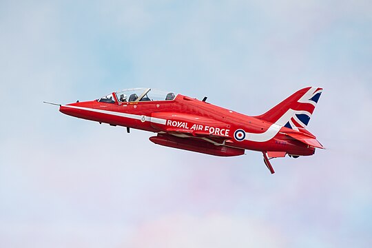 Red Arrows BAe Hawk T.1A (reg. XX311) with coloured smoke in the background at the Royal International Air Tattoo 2023.