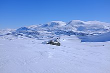 Montagnes arrondies dans un paysage enneigé.