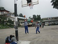 Schoolgirls shooting hoops among the Himalayas in Dharamsala, India.