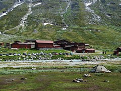 Ensemble de bâtiments rouges et parking au fond d'une vallée.