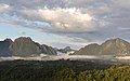 Brume ensoleillée dans les montagnes, arbres verts et nuages bleus dans le ciel, tôt matin, pendant la mousson, vue sud-ouest du mont Nam Xay, à Vang Vieng.