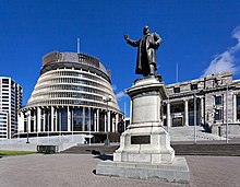 A block of buildings fronted by a large statue.