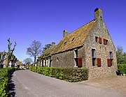 Vooraanzicht van de herbouwde kosterij.