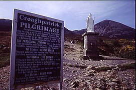 Notice at base about Stations for Catholic climbers, with statue of Saint Patrick