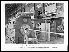 A photograph of two centrifugal casting machines inside a large factory warehouse. The photo caption reads “WATERTOWN ARSENAL Centrifugal Casting Equipment – Showing 17A and 16 Centrifugal Casting Machines.”