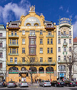 La façade sur rue d'un bâtiment art nouveau, à dominante jaune, à cinq étages.