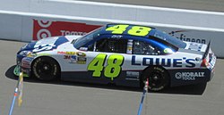 A photograph showing the left-hand side of a blue and white racing car adorned with the number 48 and sponsors logos