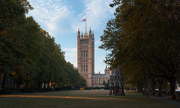 Palace of Westminster Victoria Tower with Victoria Tower Gardens South including Buxton Memorial Fountain in the foreground, in evening light.