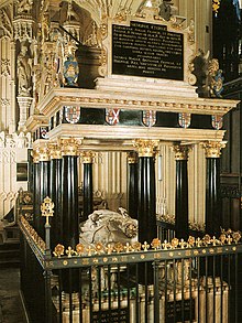 A large rectangular monument with black columns and railings