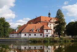 Lnáře Stronghold and Lnáře Castle (in the background) on the shore of Zámecký Pond