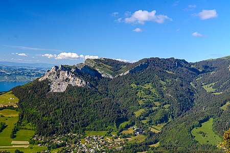 Vue depuis le mont Baron sur le synclinal perché des Mémises. La géométrie de la falaise est plus accentuée que ne l'est la géométrie du pli. Les couches sont plus horizontales et l'érosion a surcreusé la charnière du pli formant un vallon encaissé.