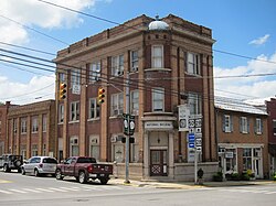 An image of a two-story beige brick neoclassical building with a colonnaded portico, and topped by a dome