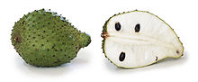 soursop fruit, whole and in section. It is green with scales has white flesh and black seeds.