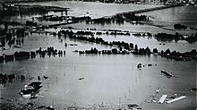 Aerial view of remnants of a populated area inundated by a flood.