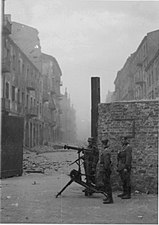 NARA copy #37, IPN copy #35 Securing a street MG08 at the gate on Nowolipie Street intersection with Smocza Street, looking East. In the back Nowolipie 56.