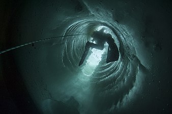 Scientific polar diver near the French scientific Dumont d'Urville base in Antarctica, photographed inside an ice tube, drilled using oil drilling techniques to allow researchers access to water. (Erwan Amice)