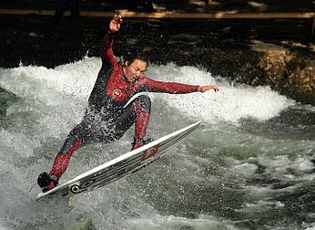 Eisbach, um braço lateral do rio Isar, é um pequeno rio artificial com uma extensão de dois quilômetros, que flui pelo Jardim Inglês (Englischer Garten) em Munique, Alemanha. Logo após passar uma ponte, perto do museu de arte Haus der Kunst, o rio forma uma onda estacionária com uma altura de cerca de um metro, que passou a ser um local popular para a prática de surfe em rio. (definição 3 836 × 2 792)