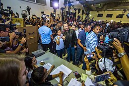 Nayib Bukele and Gabriela Rodríguez posing for press photographers at a campaign rally