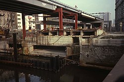 Werkzaamheden voor de aanleg van de metrotunnel en autotunnel in 1984. Op de achtergrond wordt het oude viaduct afgebroken.