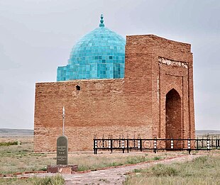 A large brick building with a round bright blue dome.