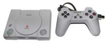 Una consola i un controlador PlayStation Classic sobre un fons blanc pur.