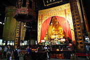 Puji Temple's Universal Treasure Hall features an 8.8 meter high seated 8 petal Vairocana-crowned Guanyin Bodhisattva accompanied by Sudhana and Nāgakanya. Adjacent on both sides are statues of 32 forms of Guanyin Bodhisattva.