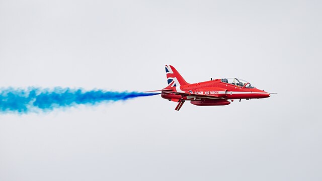 Red Arrows BAe Hawk T.1A (reg. XX177) with blue smoke at the Royal International Air Tattoo 2023.