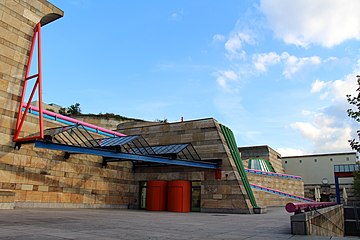 Contradiction (in this case, the mix between monumental curving forms, columns, bossages, but also other Classical elements, and High-Tech glazing, with highly saturated colours) – Neue Staatsgalerie, Stuttgart, Germany, by James Stirling (1984)[46]