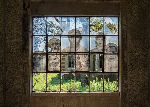 Images of immigrants painted onto windows at the ruined Ellis Island Immigrant Hospital