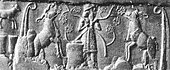 Cylinder seal impression from Uruk, showing a "king-priest" in brimmed hat and long coat feeding the herd of goddess Inanna, symbolized by two rams, framed by reed bundles as on the Uruk Vase. Late Uruk period, 3300–3000 BC.[51][52] A similar king-priest also appears standing on a ship.[53]