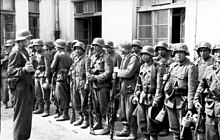 A group of uniformed soldiers in front of a building