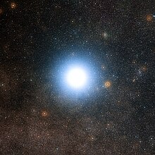 Large fuzzy white disk against a background of stars