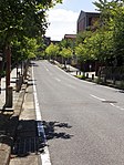 徳川園の西側を南北に走る市道。濃尾平野（手前）と大曽根面（背後）との段差を示す。 （名古屋市東区徳川町、2014年（平成26年）9月）