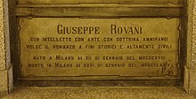 A marble gravestone on the wall of a crypt