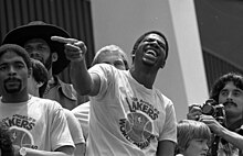 MOMENTO MÁGICO - Earvin "Magic" Johnson, trajando sua nova camiseta, diverte-se com uma piada de Jamaal Wilkes durante a recepção dos Lakers fora do Fórum, após o retorno dos campeões da NBA de Filadélfia no sábado.