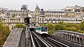 Gummibereifter Zug auf dem Viadukt, im Hintergrund die Métrostation Passy