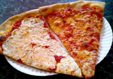 Slice of traditional New York-style pizza on right, with fresh instead of dried Mozzarella on left