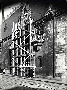 Photographie en noir et blanc prise depuis la Grande rue de la porterie. Celle-ci est entièrement masquée par une sorte de caisson en bois destiné à la protéger d'éventuels bombardements.