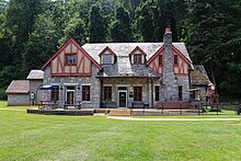 The Grand Caverns Lodge, built around 1925 in a Tudor Revival style, is a two-story stone building with a slate roof. The Lodge is located in Grand Caverns Park and sits right at the base of Cave Hill on the east side, between the hill and the South Fork River.