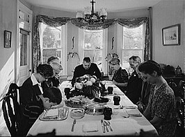 Het bidden voor het aansnijden van een kalkoen bij het Thanksgiving-diner in Neffsville, Pennsylvania, 1942