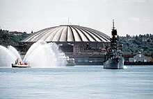 USS Leahy (CG-16) in front of the Seattle Kingdome Stadium on 6 October 1982 (6371846).jpg