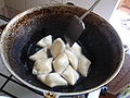 Kyrgyz boorsoq being fried in a stove-top qazan.