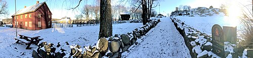 Friluftsavdelingen med Vestfoldtunet, stabbur, milepæl med inskripsjonen «Jarlsberg og Laurvigs Amt 1880 100 kilometer fra Kristiania», og annet i skyggen fra Slottsfjellet. Foto: Fordreid panoramabilde februar 2016