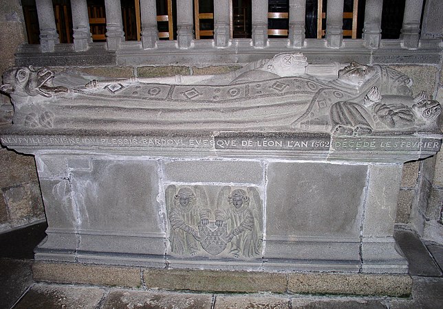 The gisant of Roland de Neufville, Bishop of Léon from 1562 to 1613. He wears a bishop's robe and mitre and the cushion on which he rests his head is supported by two angels. There is a dragon at his feet.