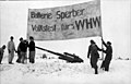 Deutsche Soldaten mit einem Transparent des Winter­hilfs­werks im besetzten Lappland, 1942