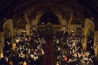 Church filled with people holding candles